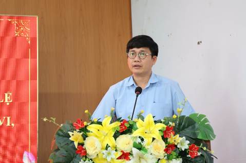 A person standing behind a podium with flowersAI-generated content may be incorrect.