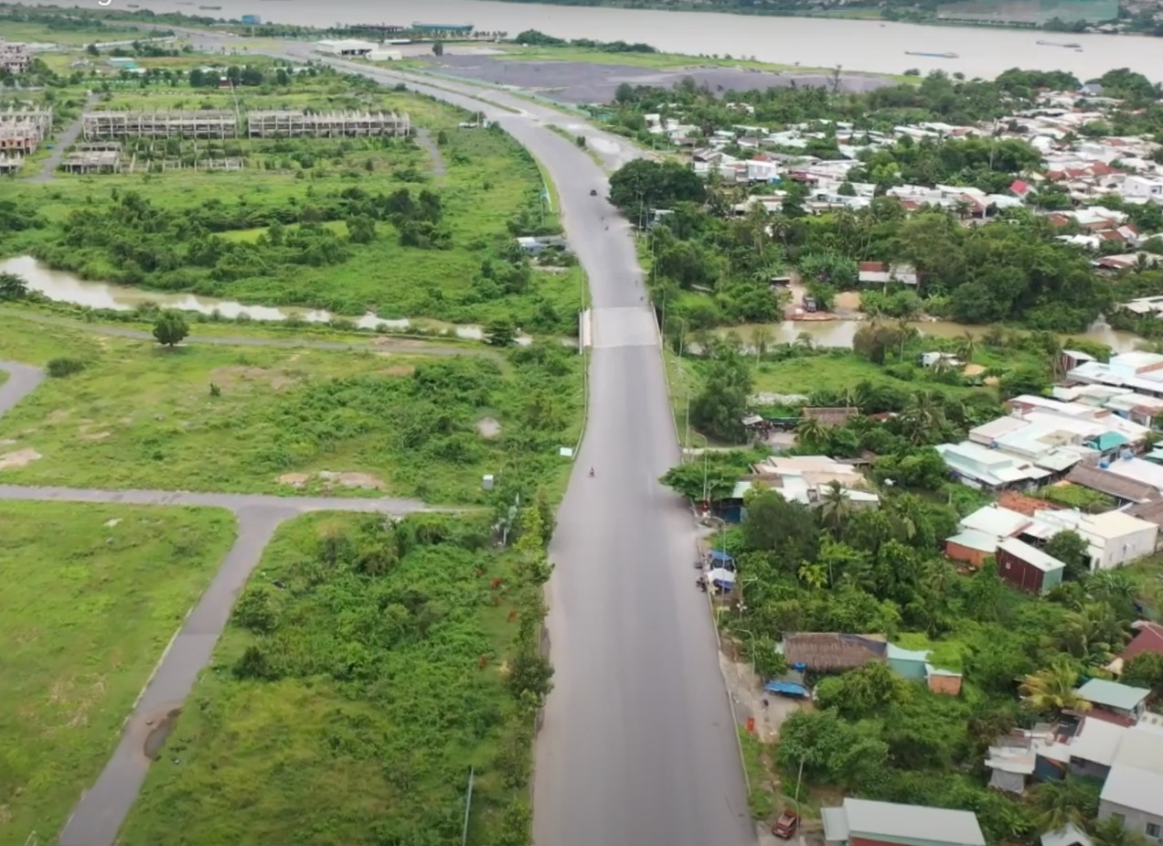 'A road between buildings and a body of water
AI-generated content may be incorrect.'