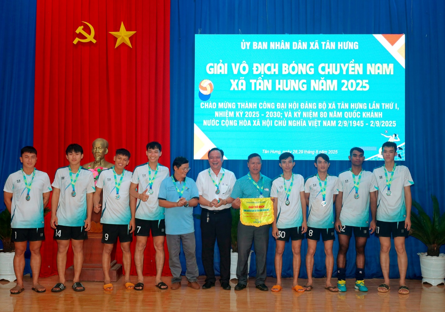 'A group of people standing in front of a screen
Description automatically generated'