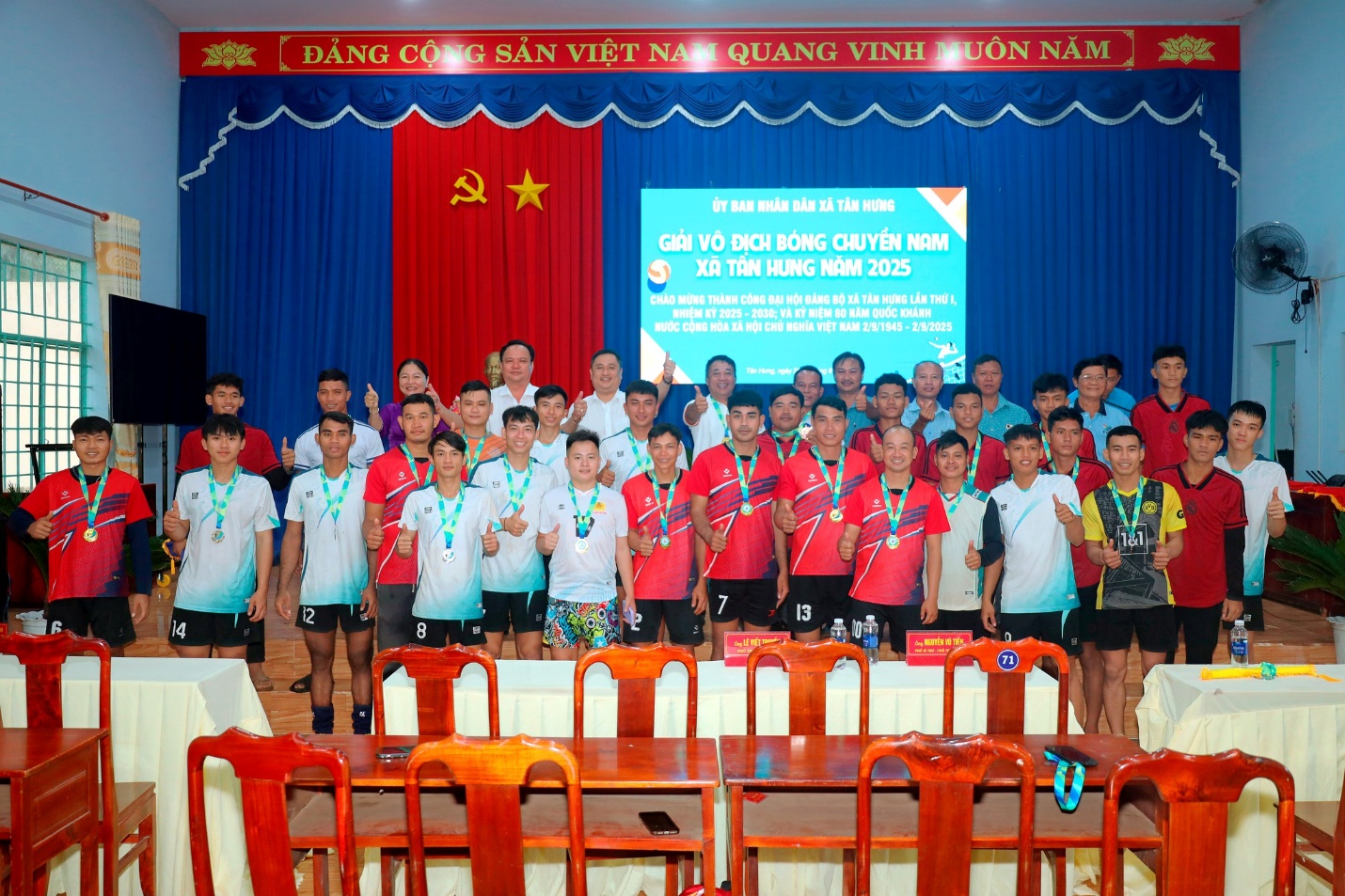 'A group of people standing in front of a stage
Description automatically generated'