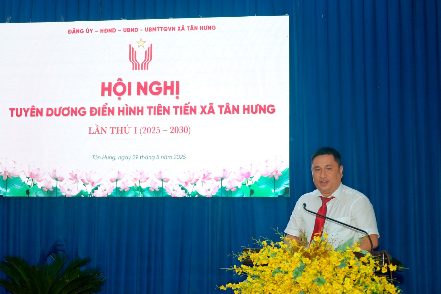 'A person standing at a podium
Description automatically generated'