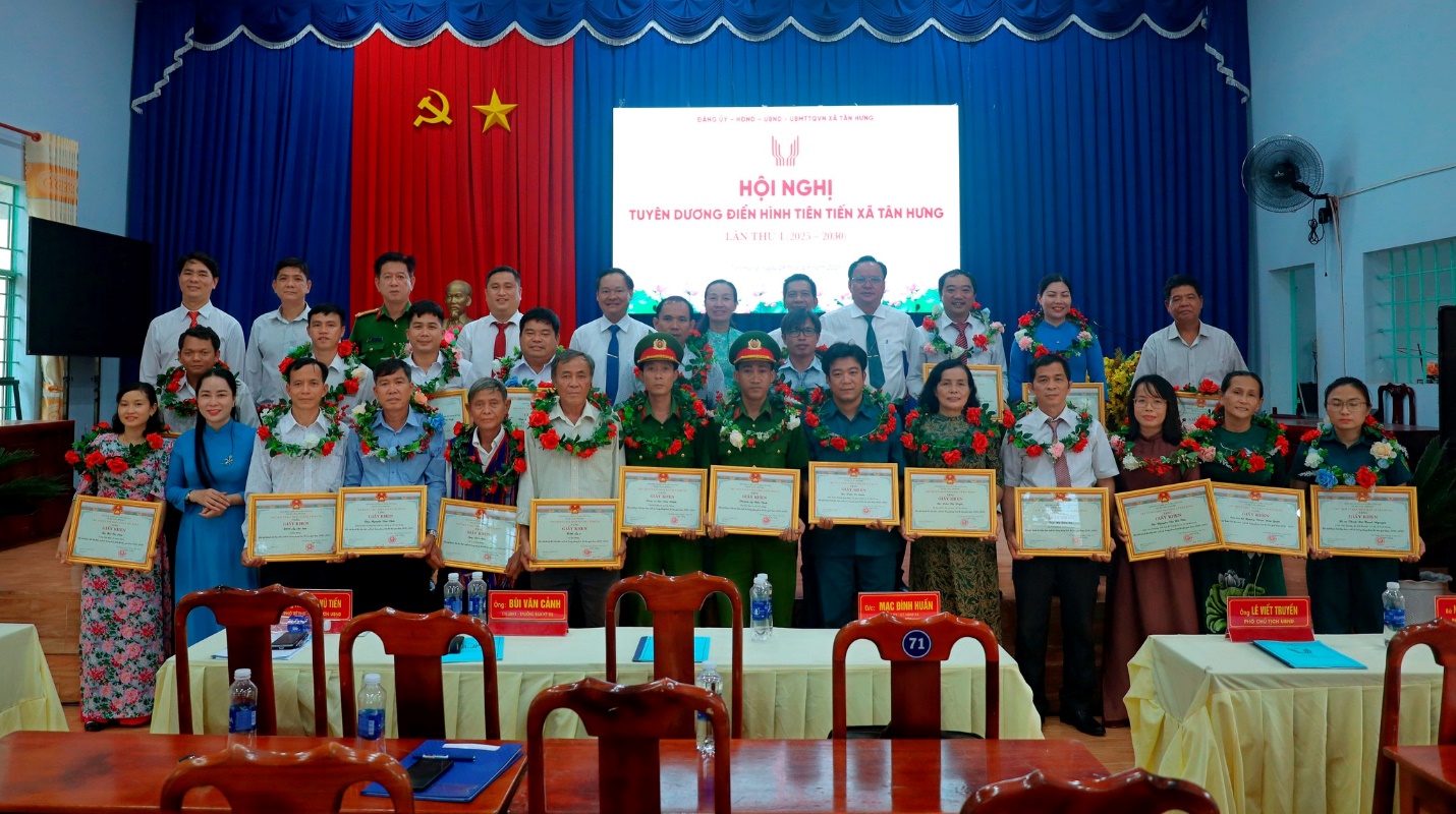 'A group of people standing in front of a screen
Description automatically generated'