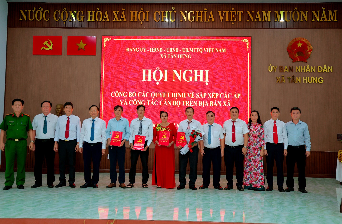 'A group of people standing in front of a sign
Description automatically generated'