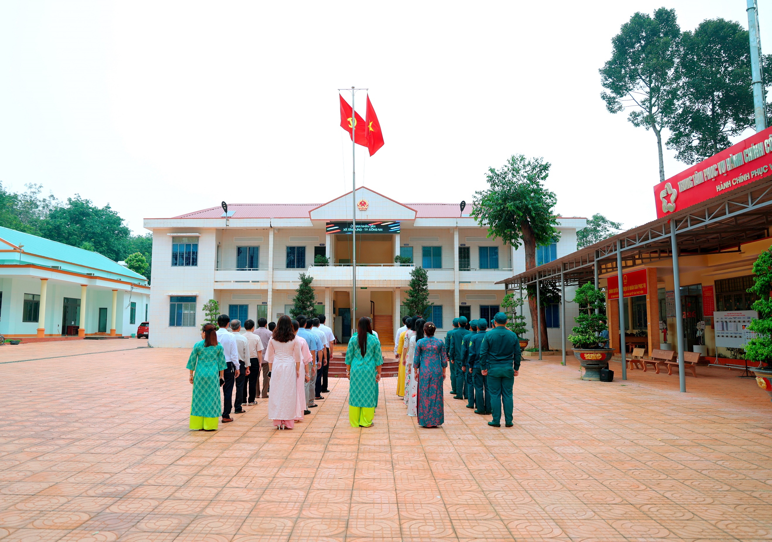 '''A group of people standing in front of a building
Description automatically generated'''