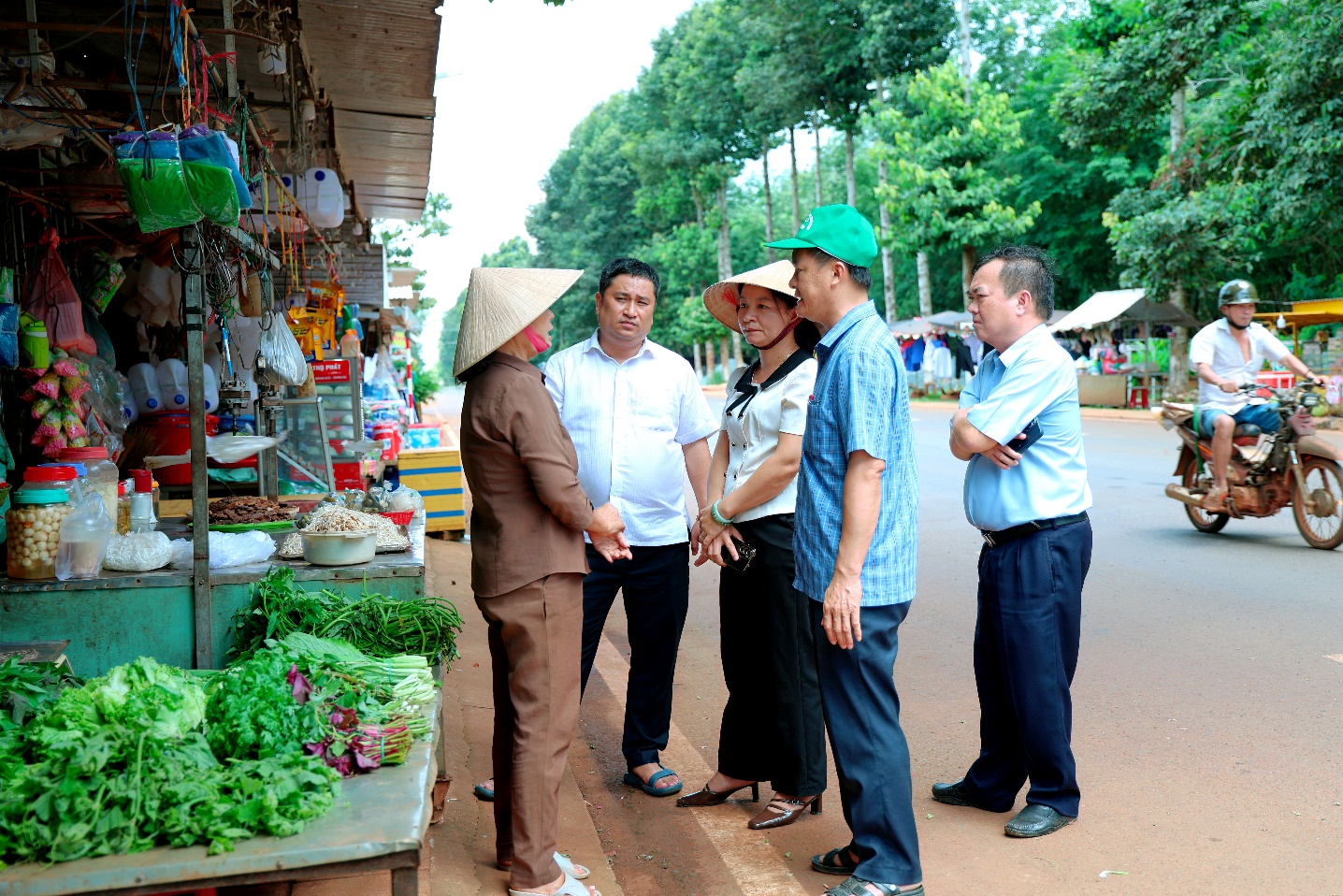 A group of people standing outside a market
Description automatically generated