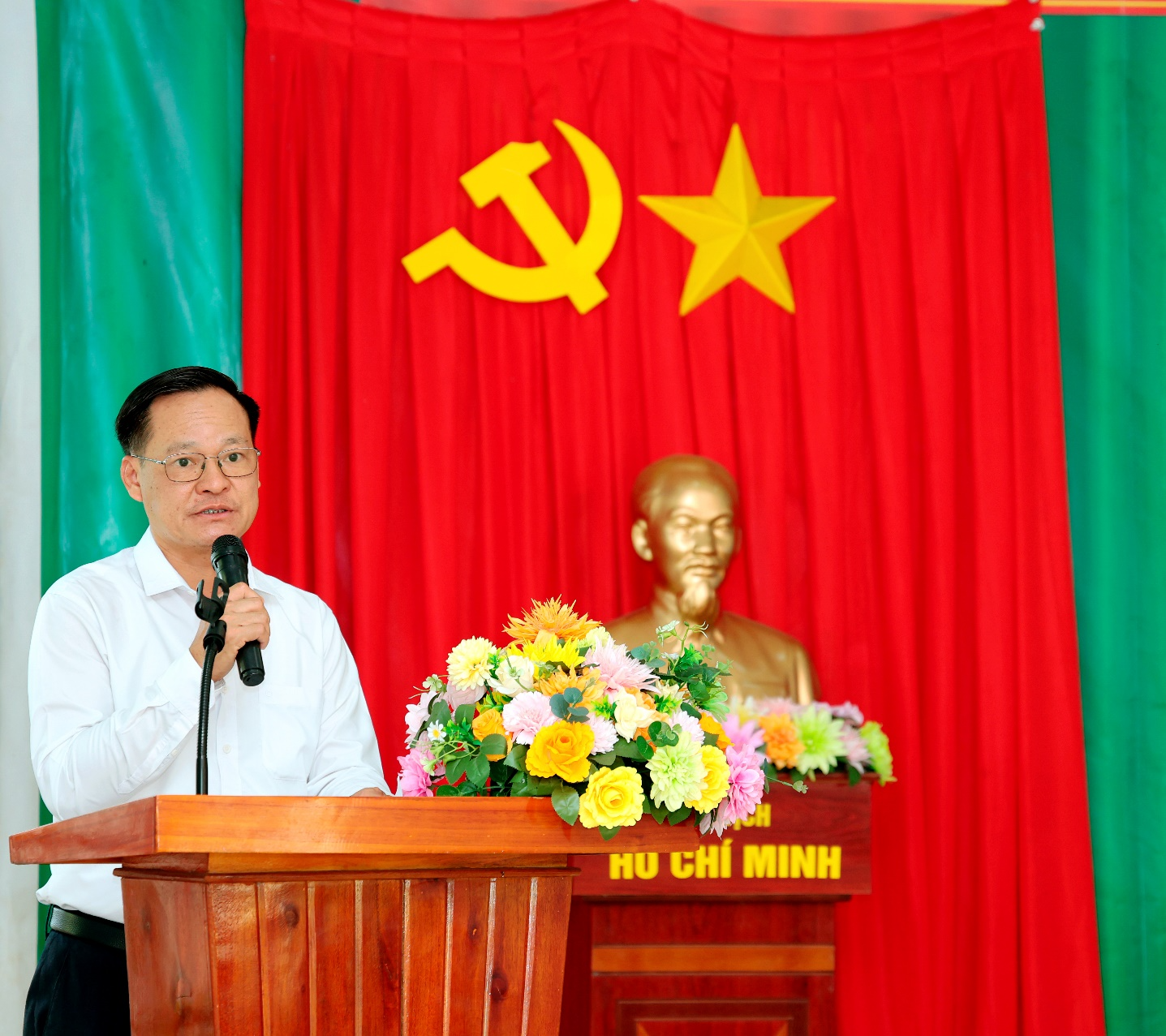 A person standing at a podium with a microphone
Description automatically generated