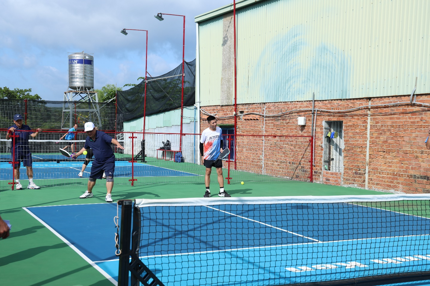 A group of people playing tennis
Description automatically generated