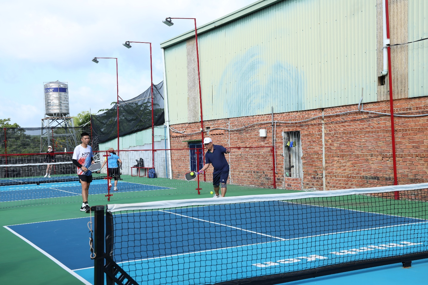 A group of people playing tennis
Description automatically generated