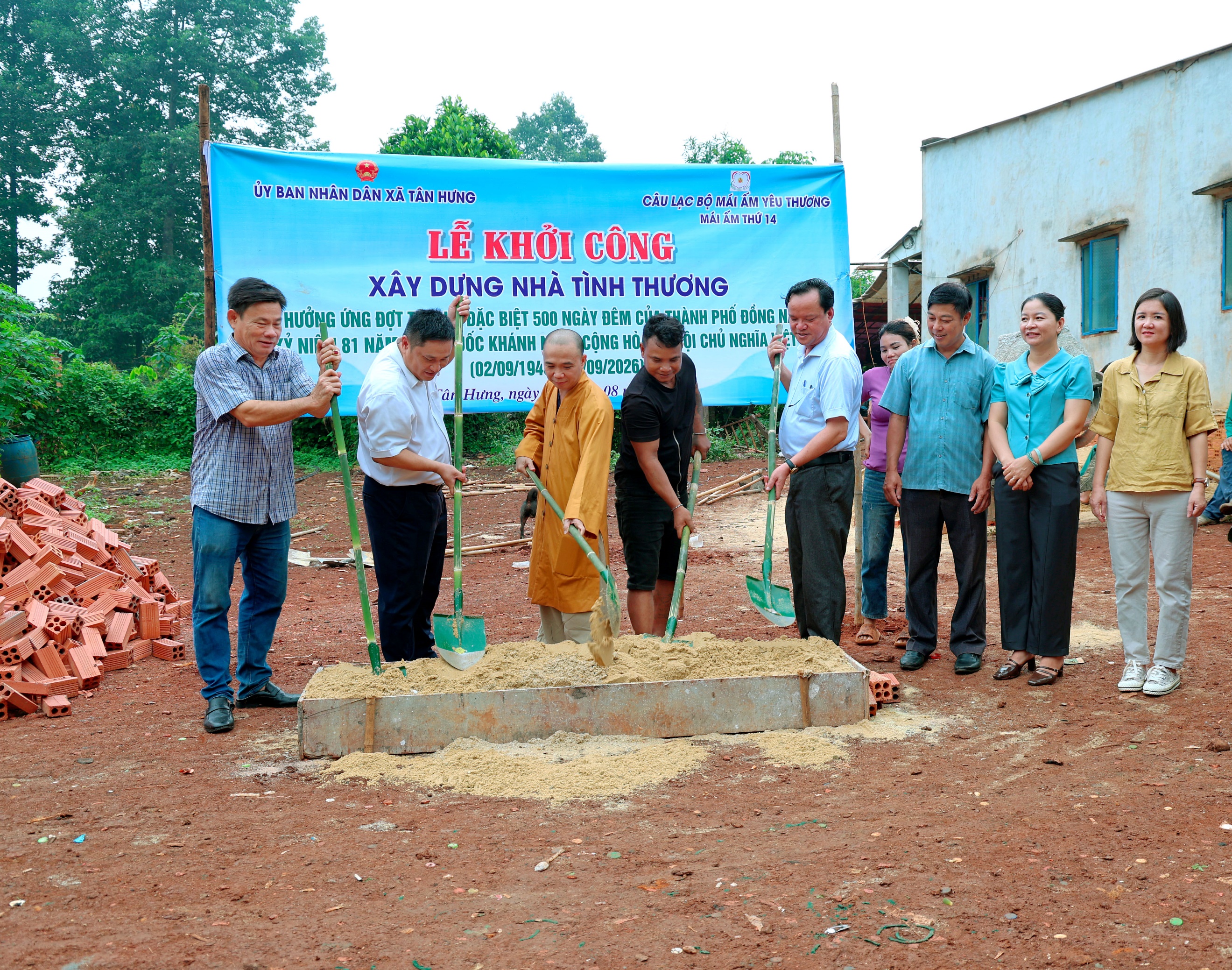 'A group of people standing around a pile of dirt
Description automatically generated'