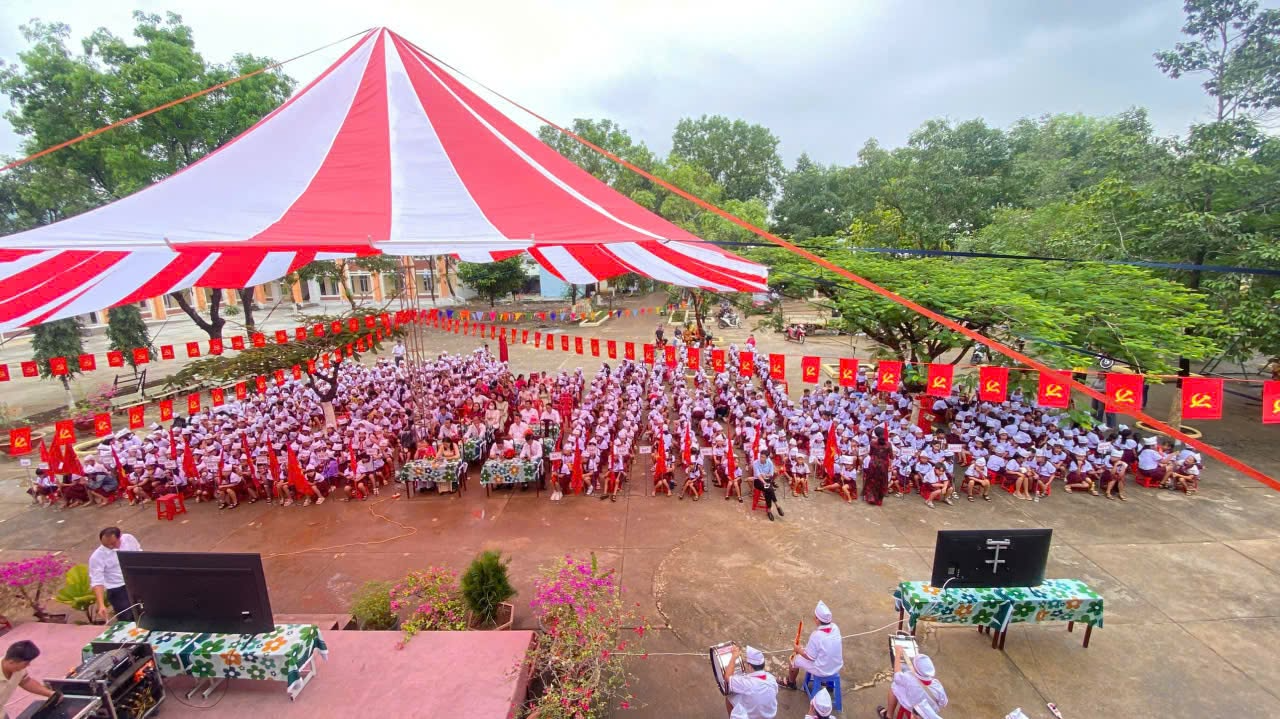 A large group of people under a red and white tent
Description automatically generated