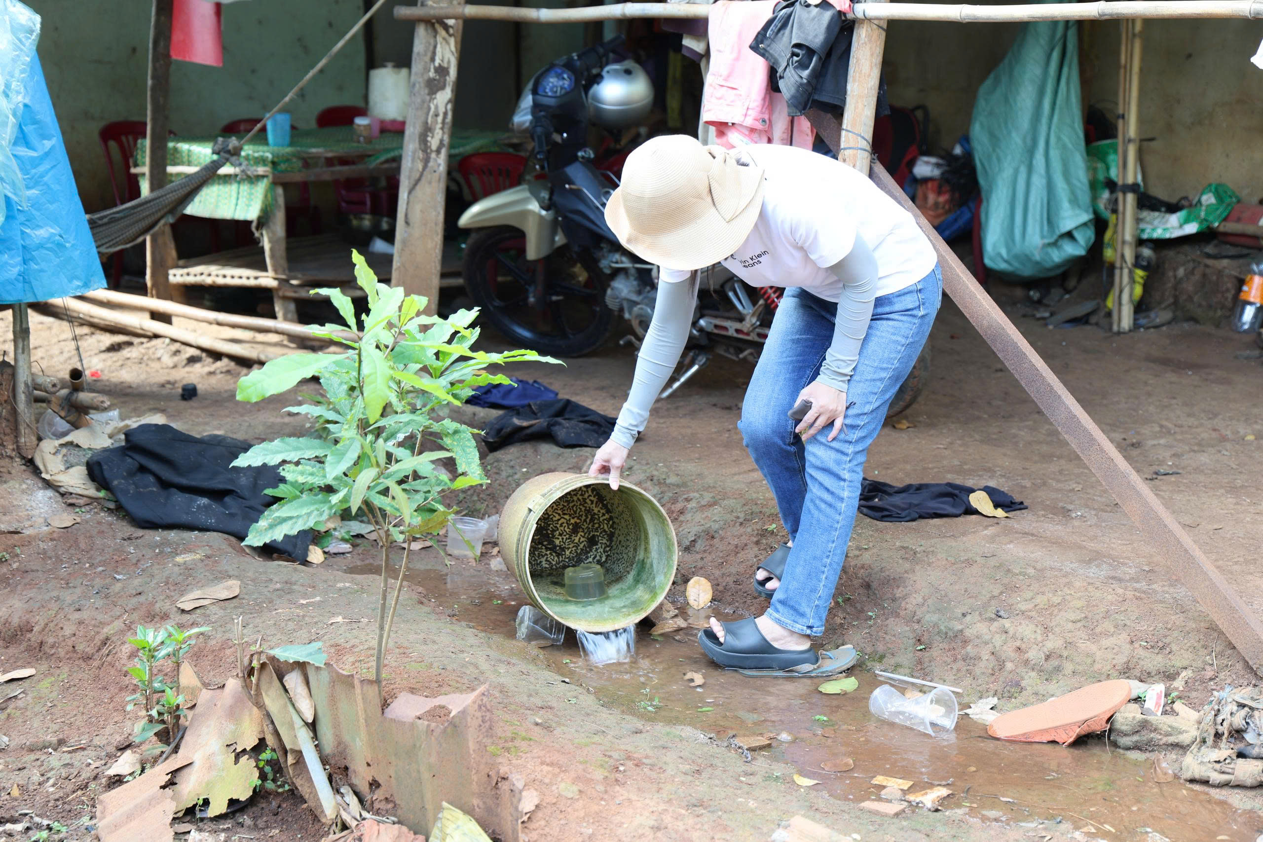 A person pouring water into a bucket
Description automatically generated