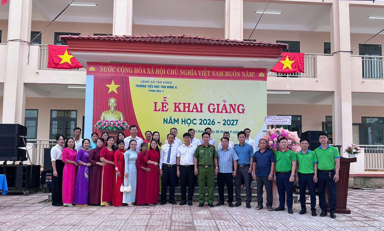 A group of people standing in front of a banner
Description automatically generated