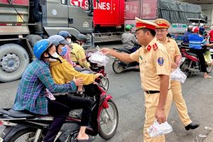 Cảnh sát giao thông Đồng Nai phát nước cho người dân về quê đón tết