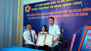 Phó Chủ tịch UBND xã Bù Đăng - Nguyễn Cảnh Thảo (Bìa trái) trao Giấy chứng nhận đăng ký kết hôn cho đôi bạn trẻ có quốc tịch nước ngoài