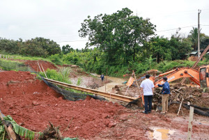 Chủ tịch UBND xã Nguyễn Tấn Lực kiểm tra hiện trường cầu tạm bị sạt lở tại thôn Bù Bưng