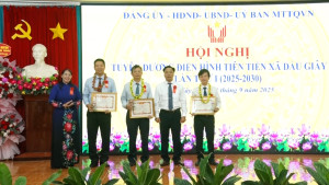 Đồng chí Lê Thị Thái, TUV, Phó trưởng Ban Dân vận và Tuyên giáo Tỉnh ủy cùng lãnh đạo xã trao hoa và giấy khen cho các gương điển hình tiên tiến tại hội nghị