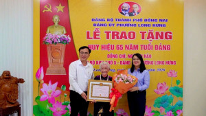 Đ/c Nguyễn Thị Như Ý - Thành ủy viên, Bí thư Đảng ủy, Chủ tịch HĐND phường Long Hưng và đ/c Kiều Minh Sinh - Phó Bí thư Thường trực Đảng ủy trân trọng trao Huy hiệu 65 năm tuổi Đảng cho đảng viên Ngô Thị Hảo