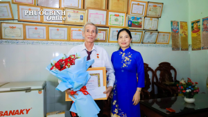 Đồng chí Phạm Thị Anh Thư - Phó Bí thư Thường trực Đảng ủy phường trao Huy hiệu Đảng tại nhà cho cho đảng viên cao tuổi.