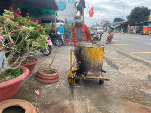 Đơn vị thi công đang tiến hành sơn kẻ vạch phạm vi bảo vệ kết cấu hạ tầng tại tuyến đường quốc lộ 20 thuộc ấp Phú Cường, xã Thống Nhất (1)