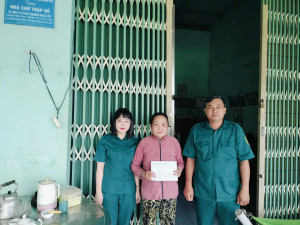 Đồng chí Phạm Văn Hải - Phó Bí thư chi bộ Quân sự xã trao tiền phụng dưỡng cho bà Giang Thị Lệ Thuỷ - con liệt sĩ