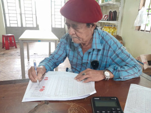 Ảnh : Người hưởng trợ cấp ký nhận tiền tại điểm chi trả trợ cấp