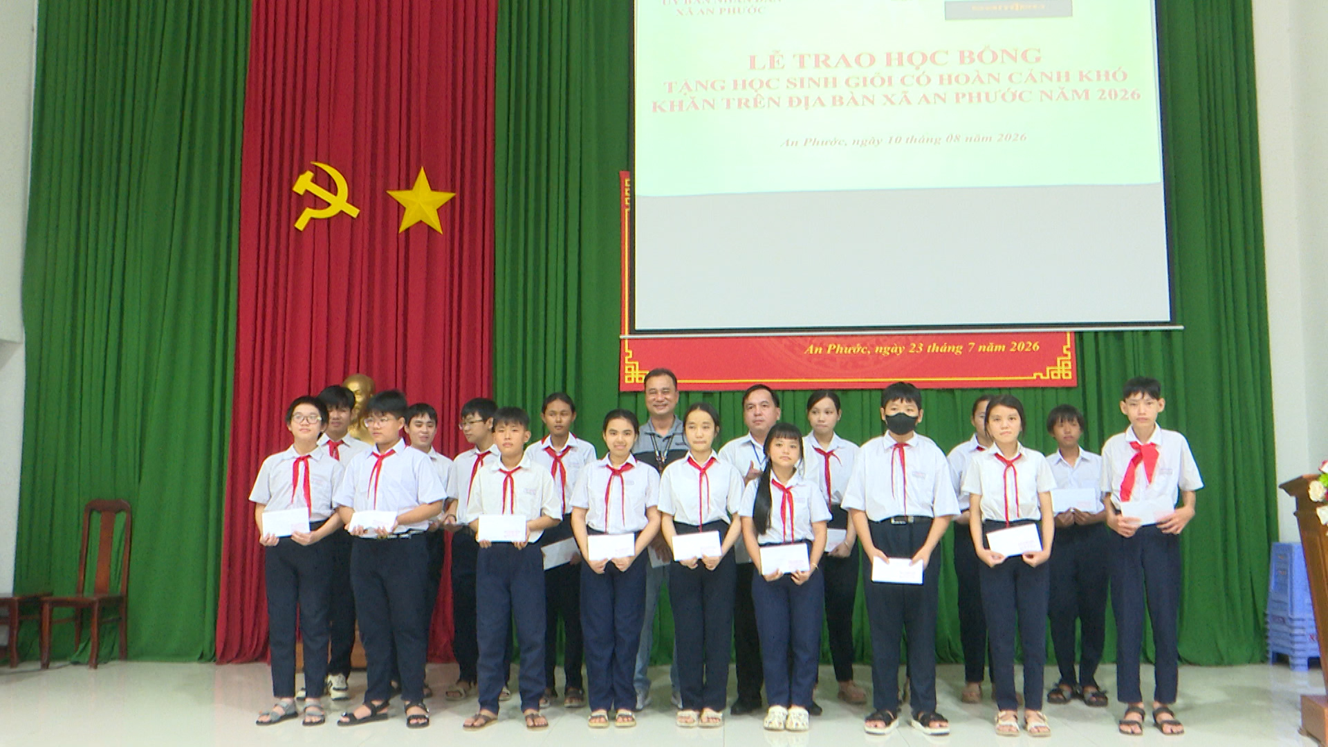 Lãnh đạo xã cùng nhà tài trợ trao học bổng cho các em