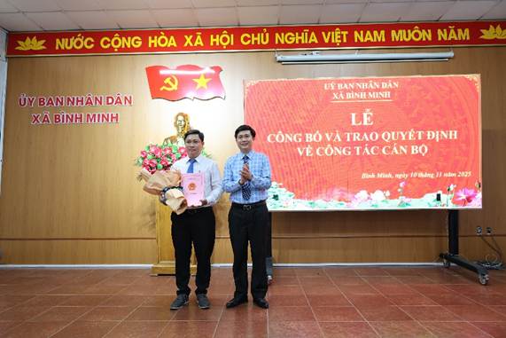 '''''Two men standing in front of a bannerAI-generated content may be incorrect.'''''