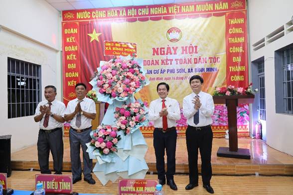 A group of men standing on a stage with a large bouquet of flowersAI-generated content may be incorrect.