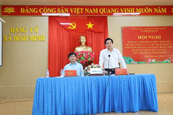 ''A person standing at a table with a microphone

AI-generated content may be incorrect.''