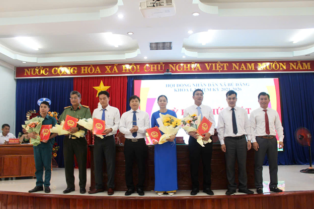 Phó Bí thư Đảng ủy, Chủ tịch UBND xã Nguyễn Thanh Tùng và 2 Phó Chủ tịch UBND huyện Trần Xuân Hiển, Nguyễn Cảnh Thảo trao quyết định và hoa cho các Ủy viên UBND xã