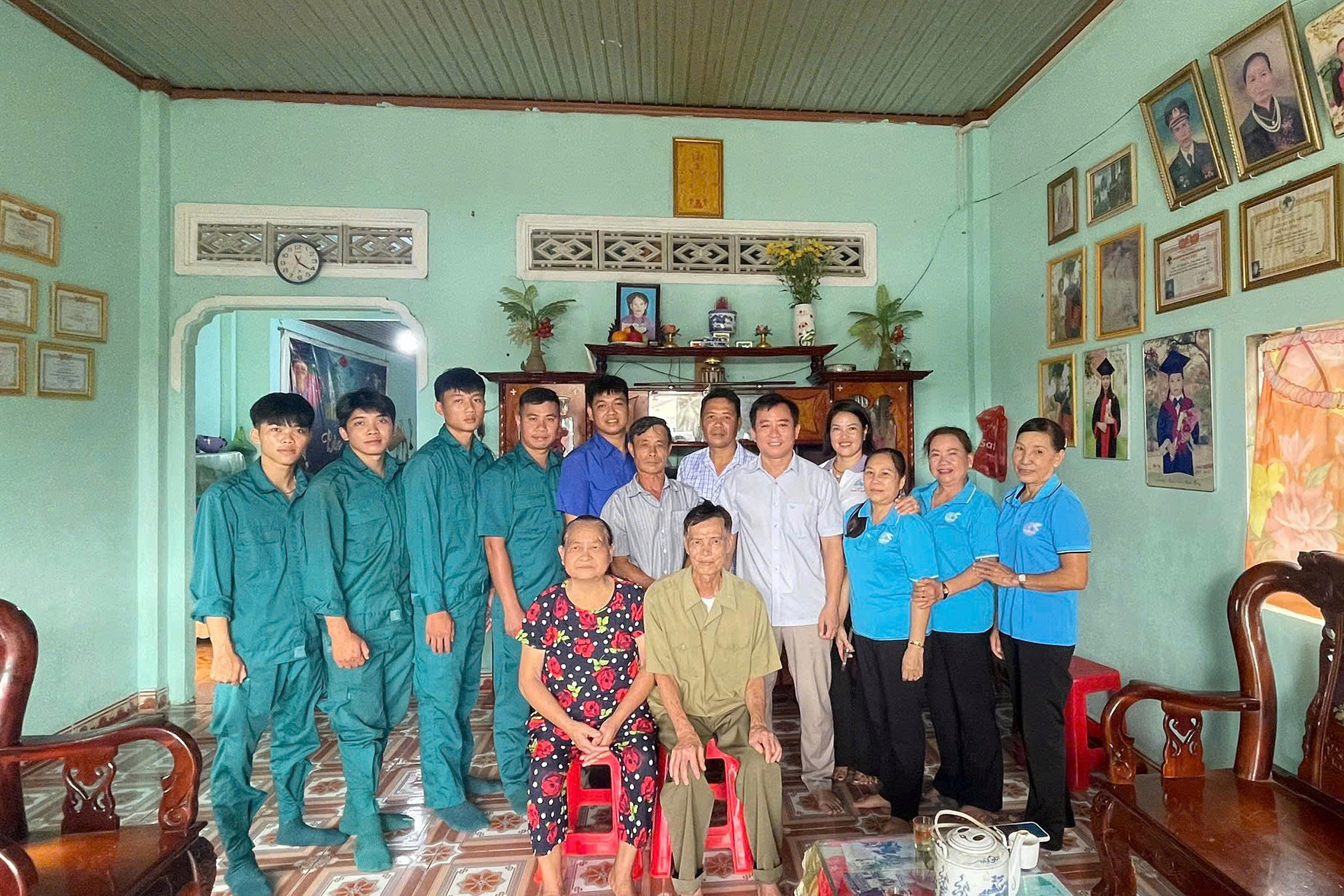 Đồng chí Nguyễn Cảnh Thảo - Phó chủ tịch UBND xã (Hàng đứng, thứ 5 từ phải sang trái) chụp hình lưu niệm với vợ chồng Thương Binh Trần Xuân Độ trong ngôi nhà mới được sơn quét khang trang, sạch đẹp