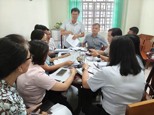 ''A group of people sitting around a table

Description automatically generated''