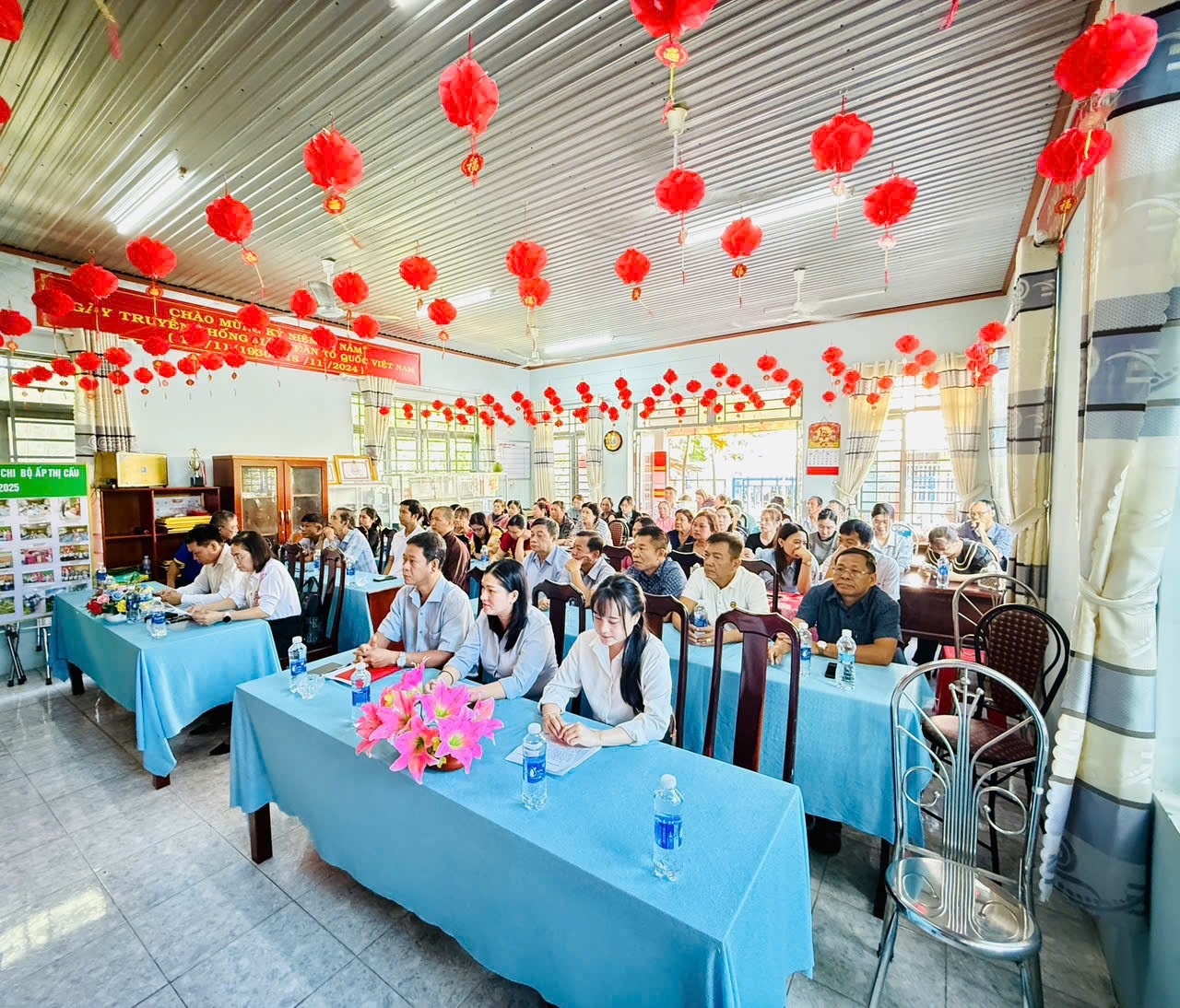 'A group of people sitting at tables in a room with red lanterns

Description automatically generated'