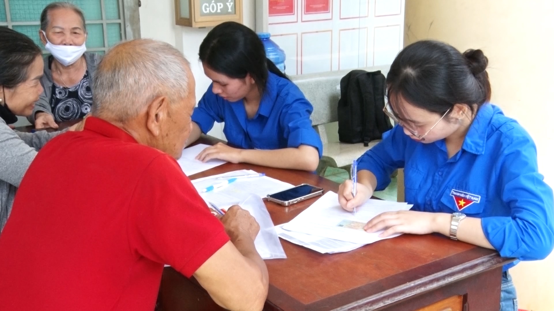 Thanh niên xã Dầu Giây hướng dẫn người dân điền các thông tin trong tờ khai khi đến giải quyết TTHC