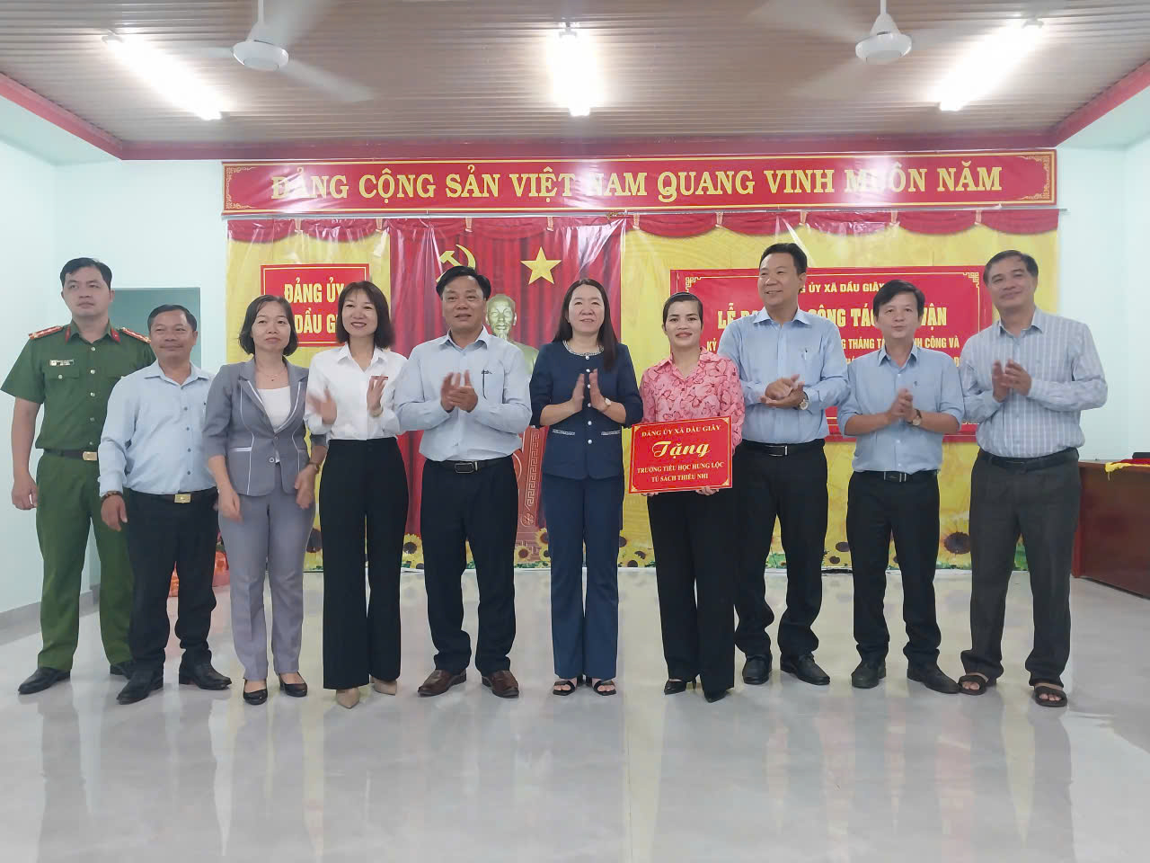 Lãnh đạo xã Dầu Giây trao bảng tượng trưng tặng tủ sách thiếu nhi cho điểm trường Tiểu học Hưng Lộc