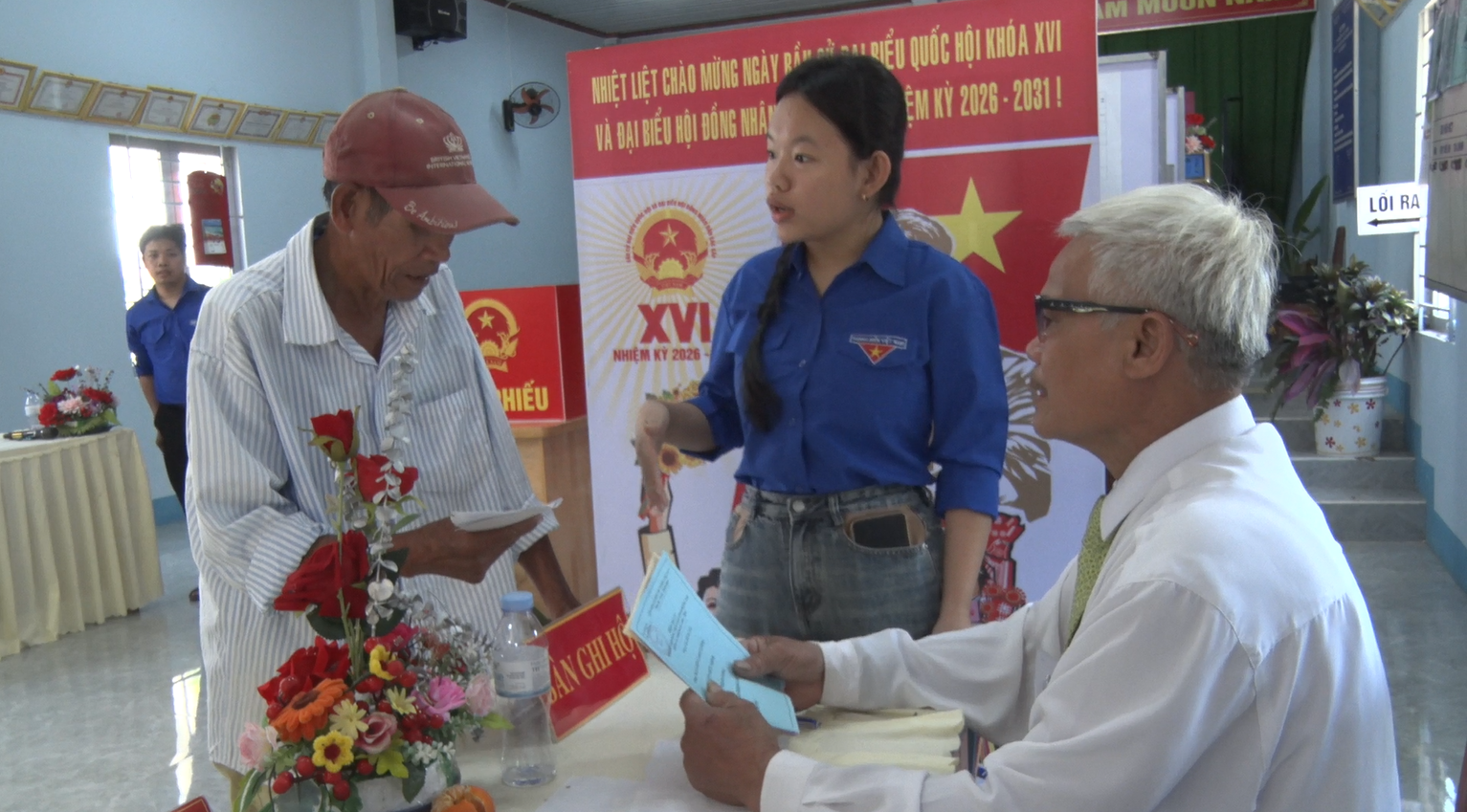 Hình Cán bộ ấp hướng dẫn cư tri gạch phiếu bầu cử