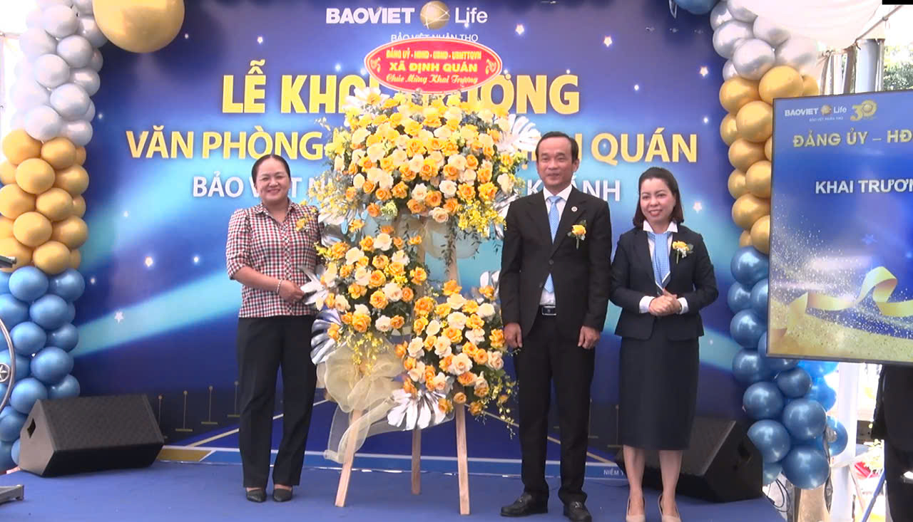 Phó Bí thư Đảng ủy, Chủ tịch UBND xã Hồ Thanh Trúc (Bên trái) trao tặng lẵng hoa chúc mừng khai trương