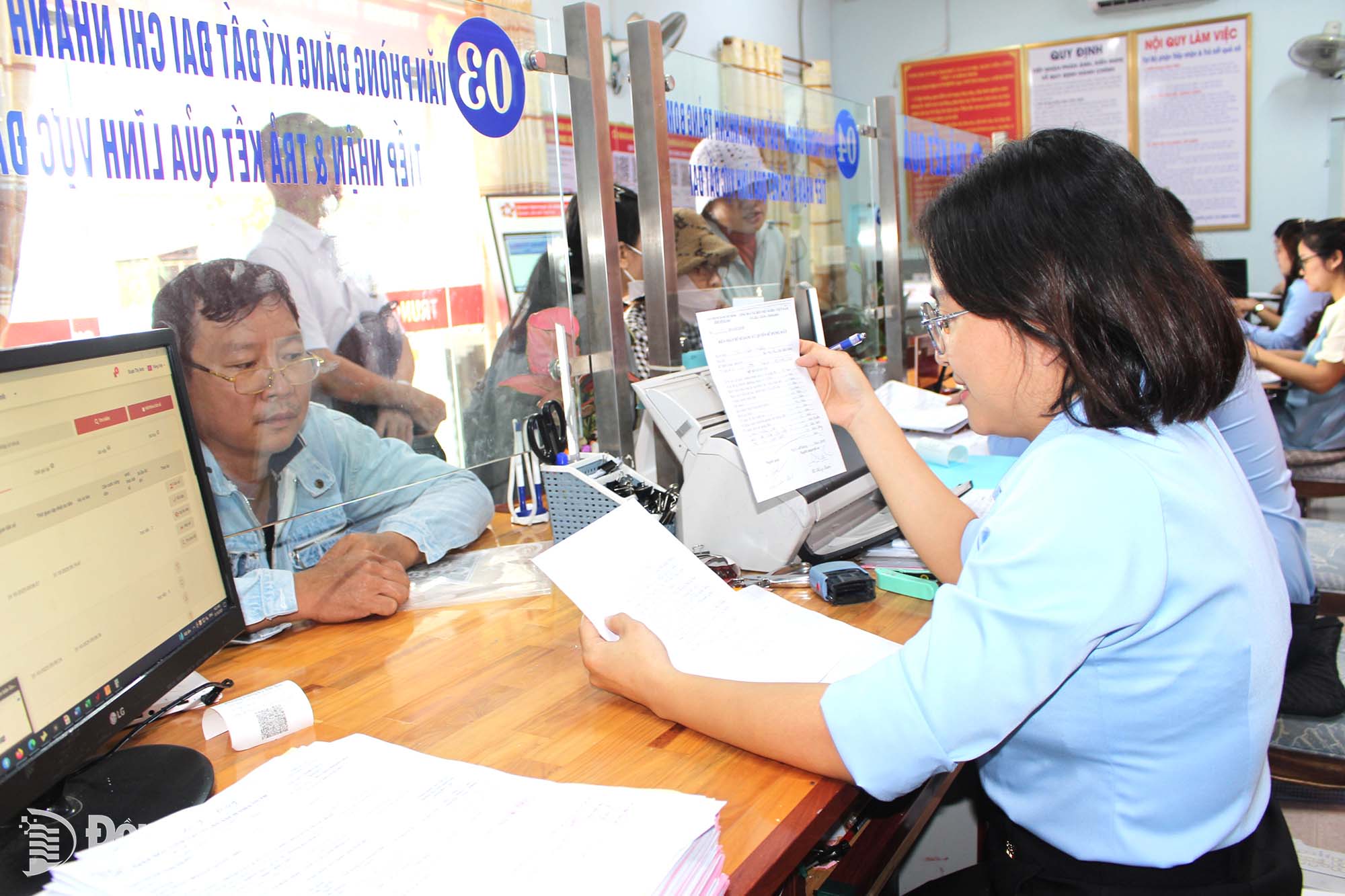 Cán bộ, công chức Trung tâm Phục vụ hành chính công xã Bình Minh hướng dẫn người dân thực hiện thủ tục hành chính. Ảnh: Hồ Thảo
