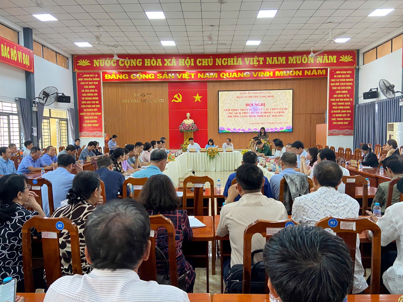 '''A group of people sitting in chairs in a room

Description automatically generated'''