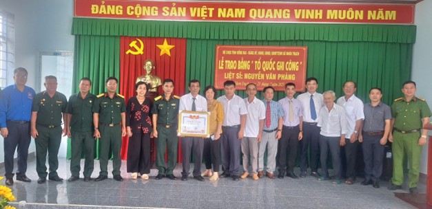 Đại diện Bộ CHQS tỉnh và lãnh đạo xã Nhơn Trạch chụp hình lưu niệm cùng thân nhân gia đình liệt sỹ Nguyễn Văn Phàng