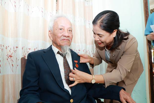 Đồng chí Nguyễn Thị Xuân Hòa trao huy hiệu 65 năm tuổi Đảng cho đảng viên Phạm Đình Ba