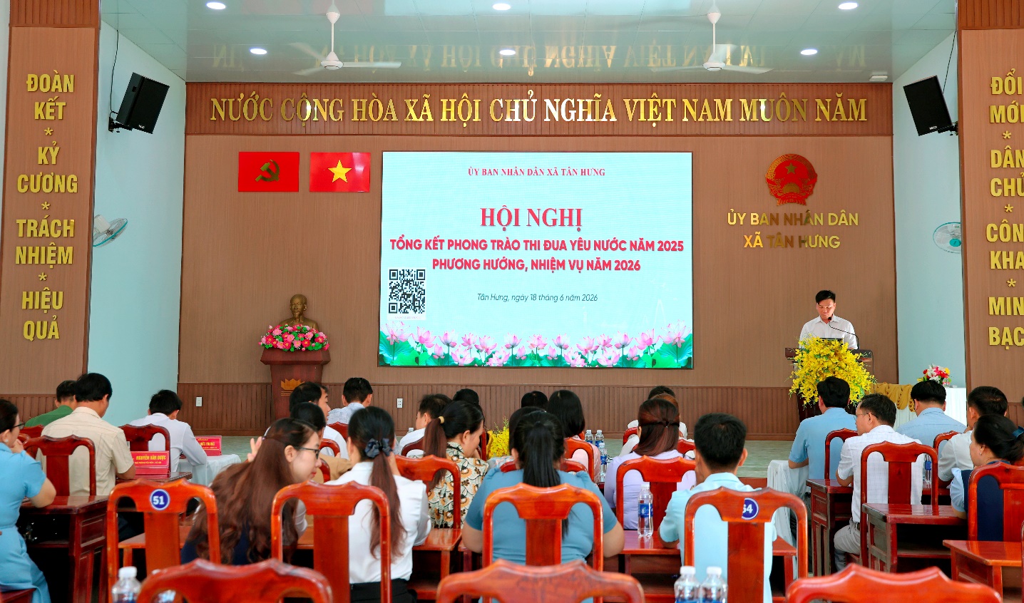 'A group of people sitting in chairs in front of a screen

Description automatically generated'