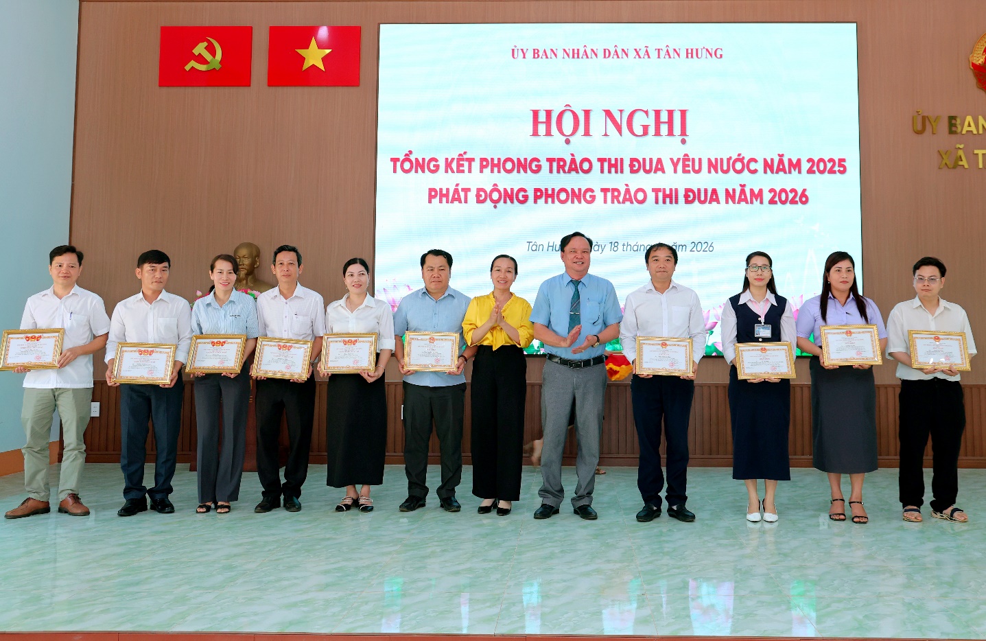 'A group of people standing in a row holding certificates

Description automatically generated'