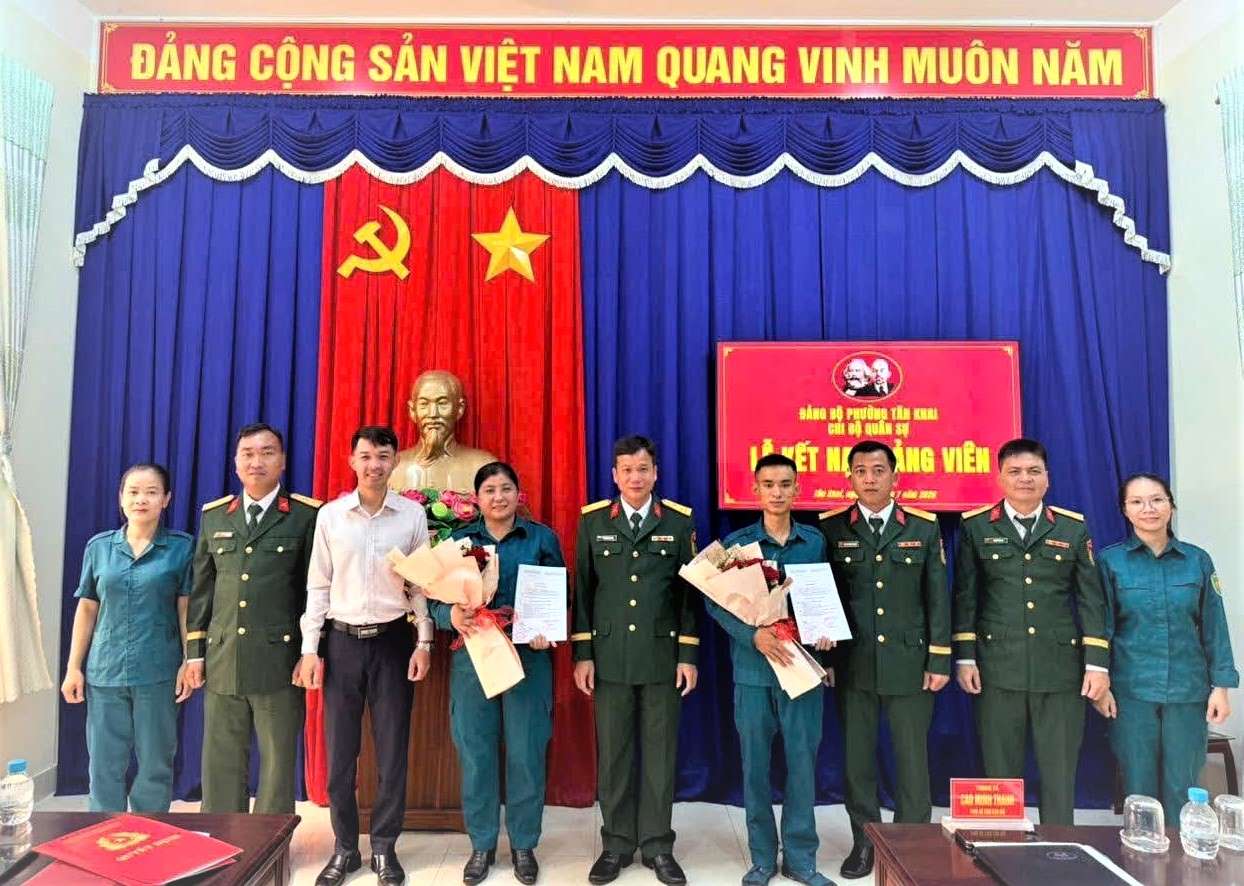 Hai quần chúng vừa được kết nạp vào Đảng cộng sản Việt Nam chụp hình lưu niệm với Chi bộ quân sự.