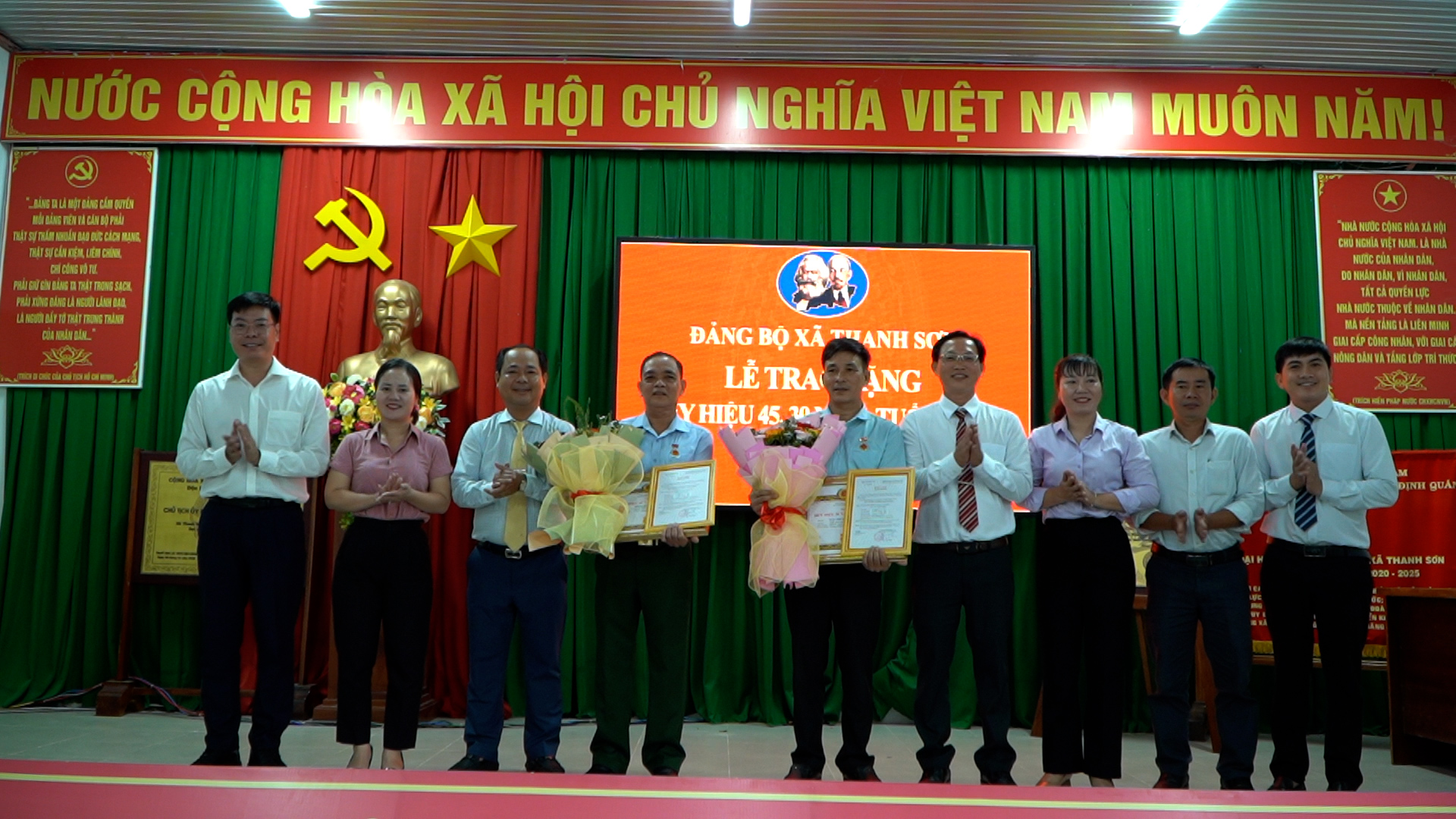 lãnh đạo xã chụp hình lưu niệm cùng các đảng viên nhận huy hiệu đảng