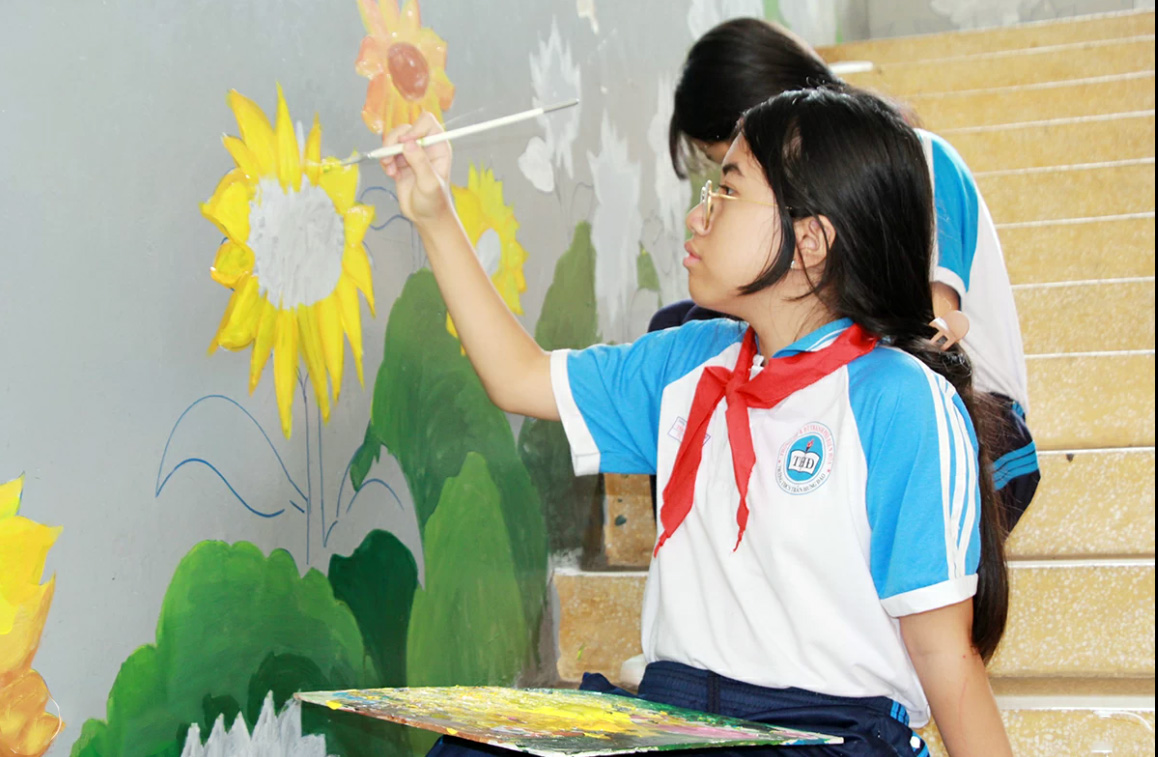 Các em đội viên, học sinh của Trường trung học cơ sở Trần Hưng Đạo  (phường Trấn Biên) tham gia khoác “áo mới” cho ngôi trường các em theo học