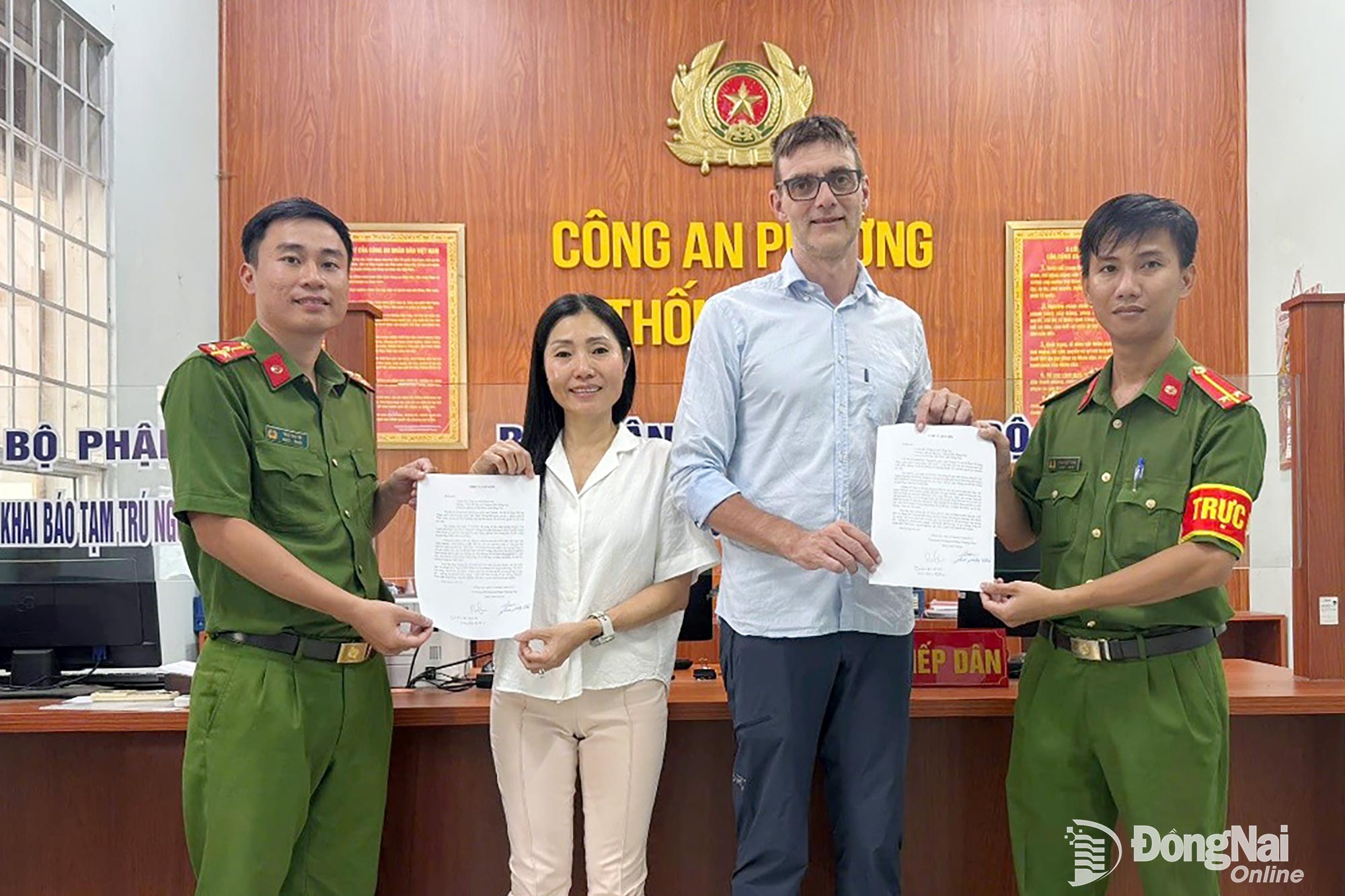 Vợ chồng ông Dominique Momeau trao thư cảm ơn cho cán bộ Công an phường Trấn Biên. Ảnh: Công an phường Trấn Biên