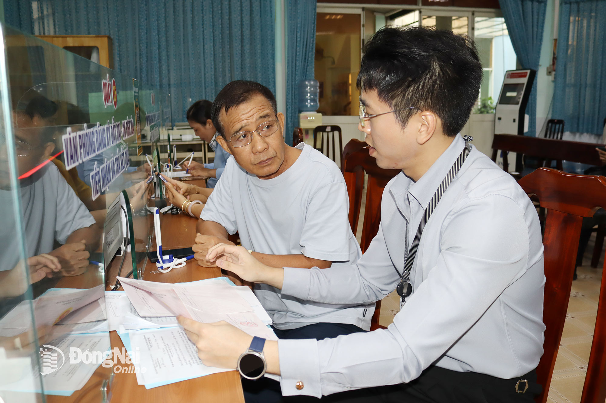 Cán bộ Văn phòng Đăng ký đất đai tỉnh Đồng Nai - chi nhánh Biên Hòa được cử đến công tác tại phường Trấn Biên, đang hỗ trợ giải quyết hồ sơ về đất đai cho người dân. Ảnh: Hoàng Lộc