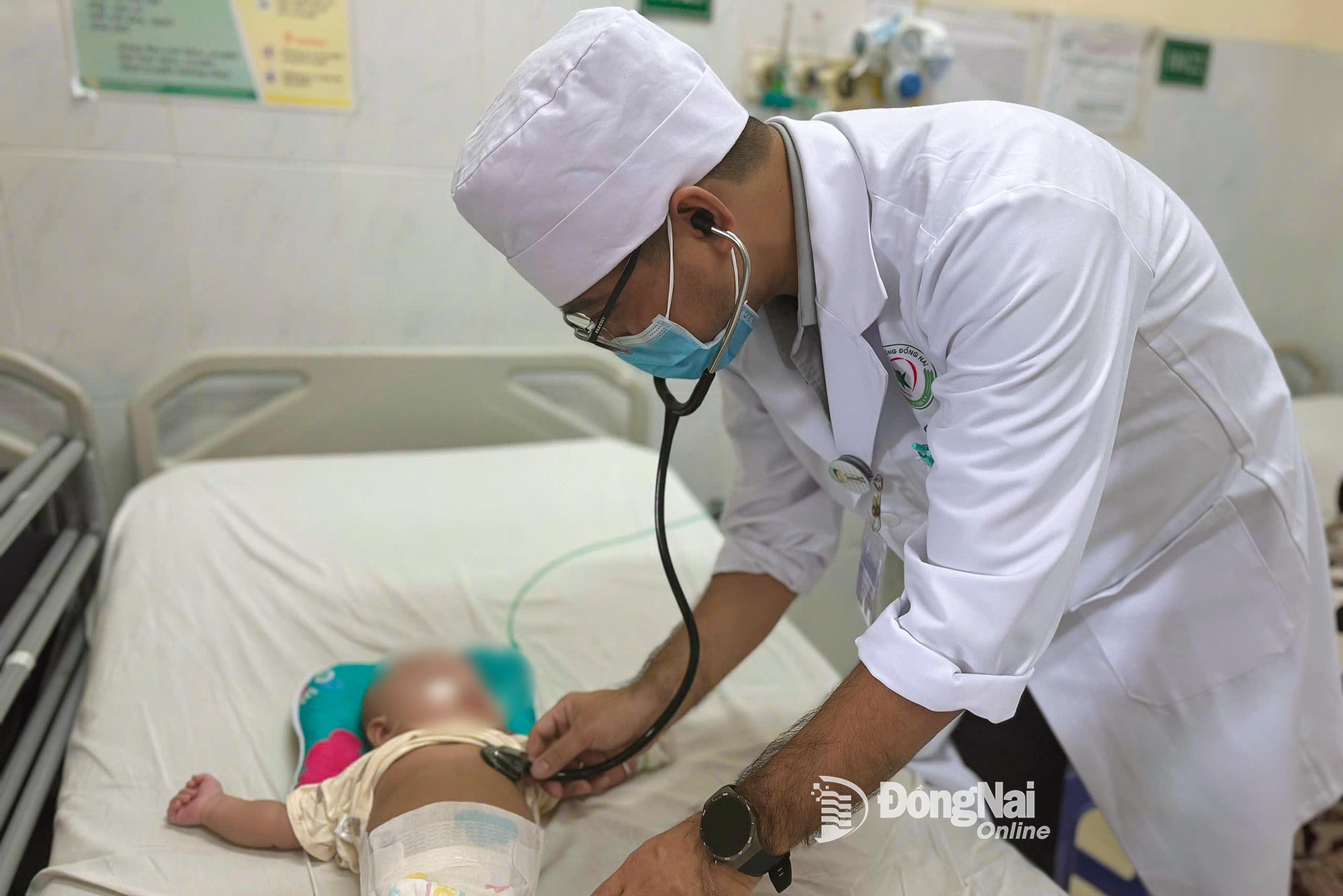 Bác sĩ tái khám cho con trai chị Hưng bị viêm phổi chữa trị tại Bệnh viện Nhi đồng Đồng Nai. Ảnh: Bích Nhàn