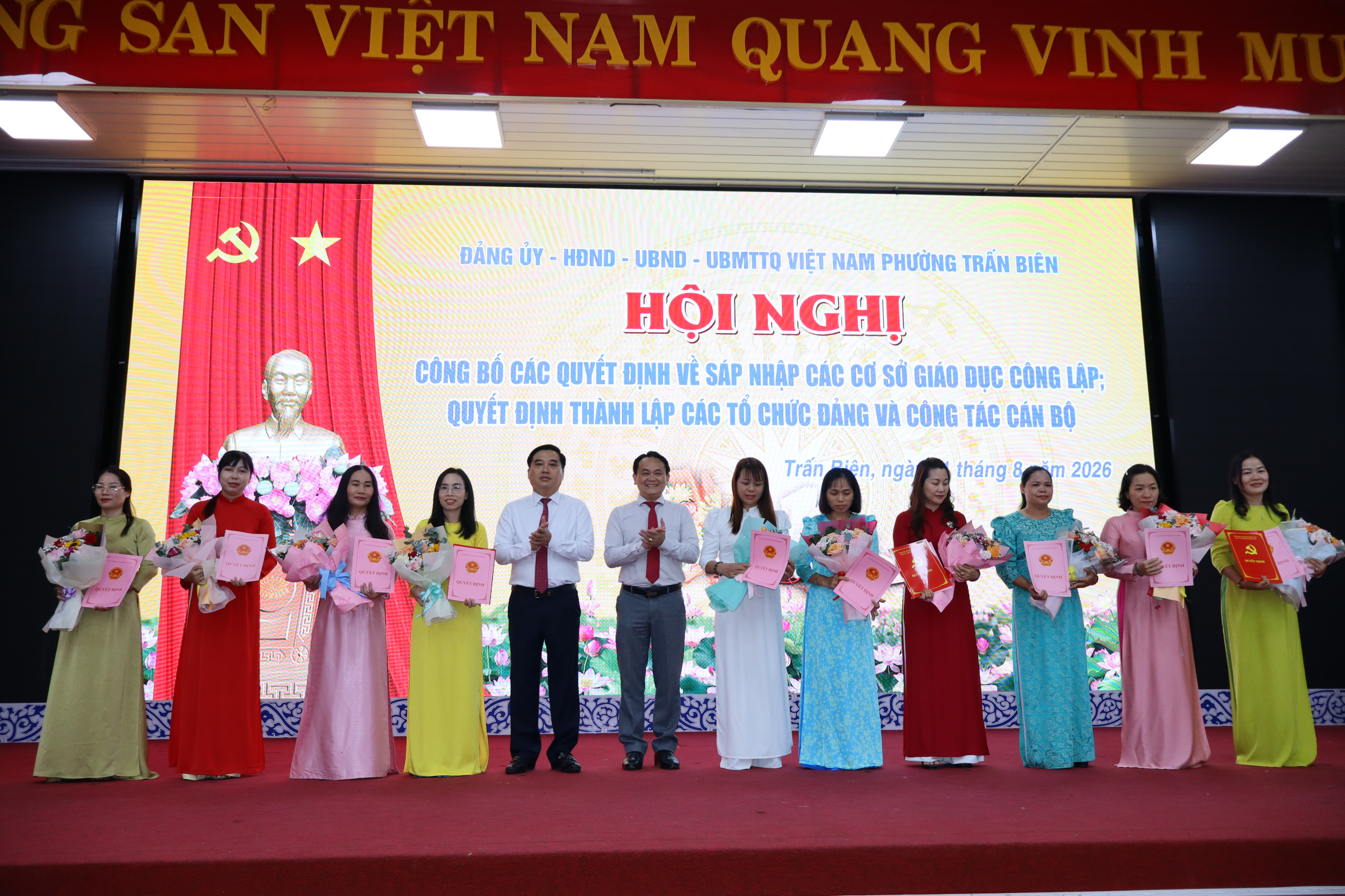 Ủy viên Ban Thường vụ Thành ủy, Bí thư Đảng ủy, Chủ tịch HĐND phường Trấn Biên Hồ Văn Nam và Phó Chủ tịch UBND phường Trấn Biên Phạm Đức Hoàng trao hoa và quyết định cho cán bộ quản lý các trường học sau sắp xếp